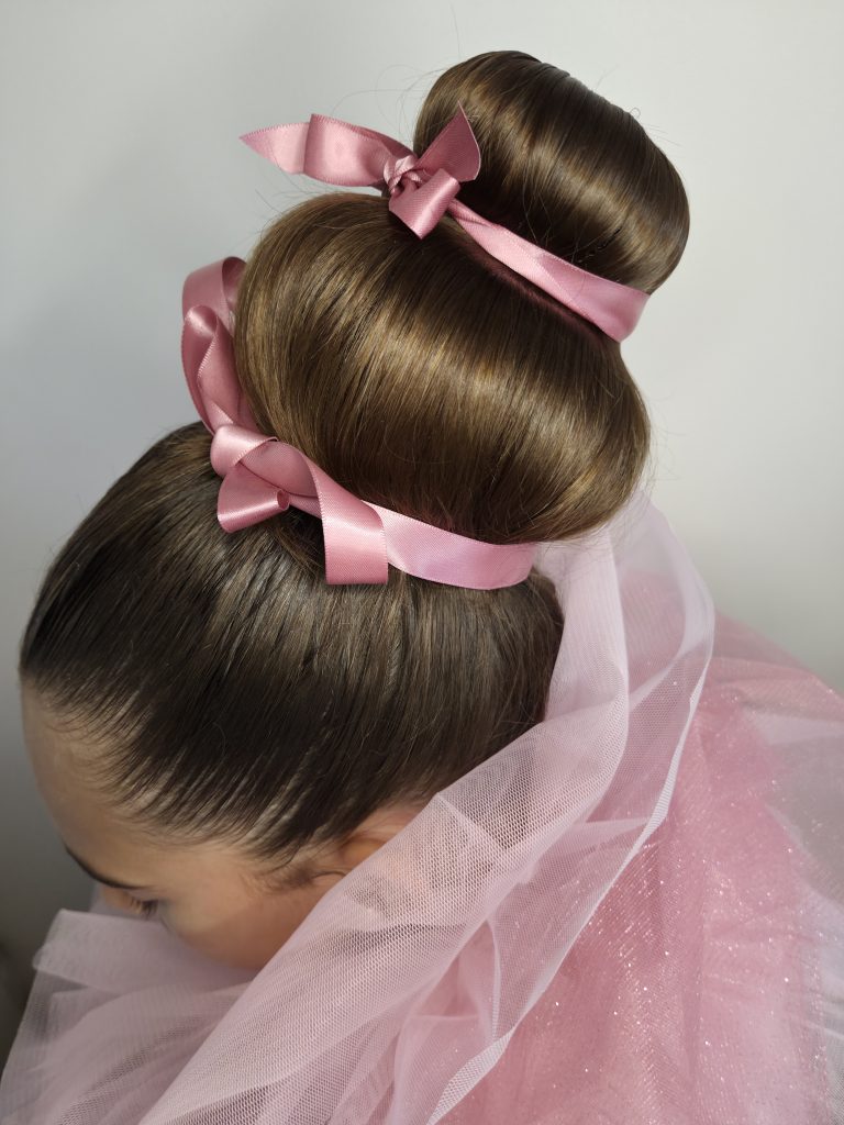 Coiffure studio Octobre Rose chignon en hauteur ruban noeud rose satiné